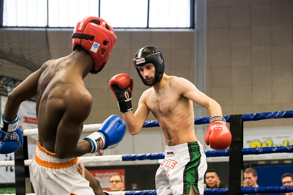 Zwei Boxer im Ring, einer mit roten Handschuhen, der andere mit blauen, bereit für den Kampf.